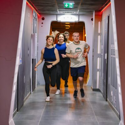 Quatre jeunes courent dans un couloir futuriste