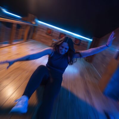 Femme glissant sur parquet sous lumière bleue
