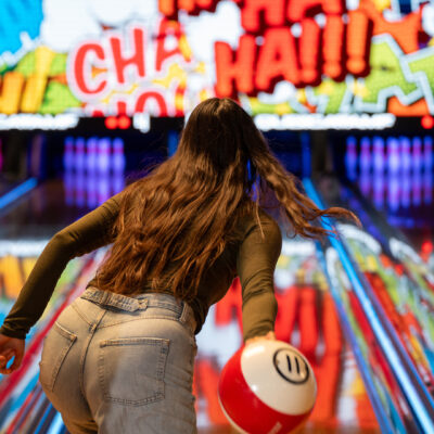 Femme lançant une boule de bowling colorée